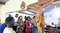 Christen vor Kreuz in Kirche im Senegal