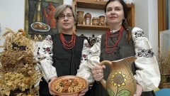 Valentyna Sobetska (l.) und Halyna Brukhouska mit dem Ährenstrauss Diduch, der Weihnachtsspeise Kutja und dem Getränk Uswar