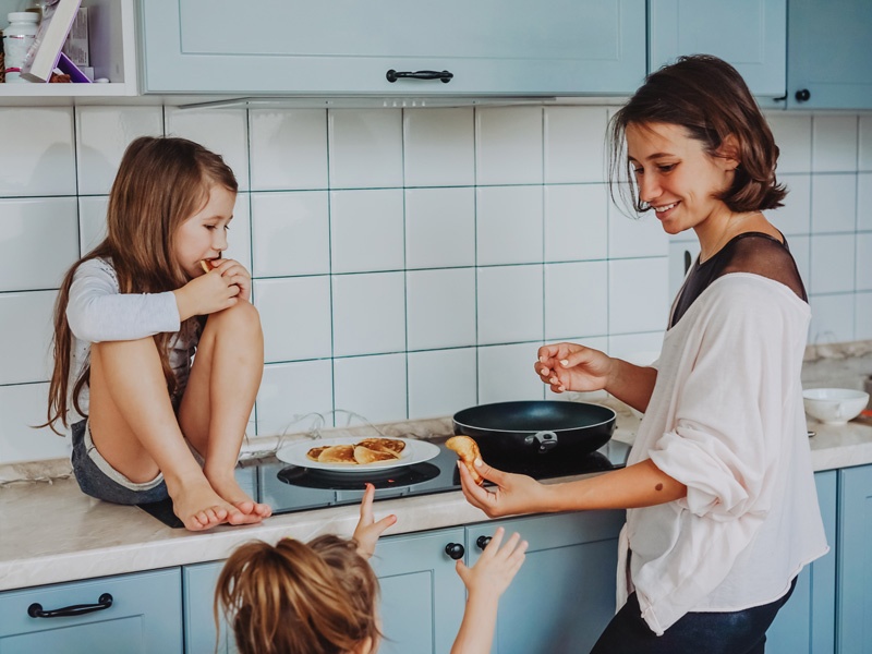 Mutter teilt Essen mit zwei Kindern.