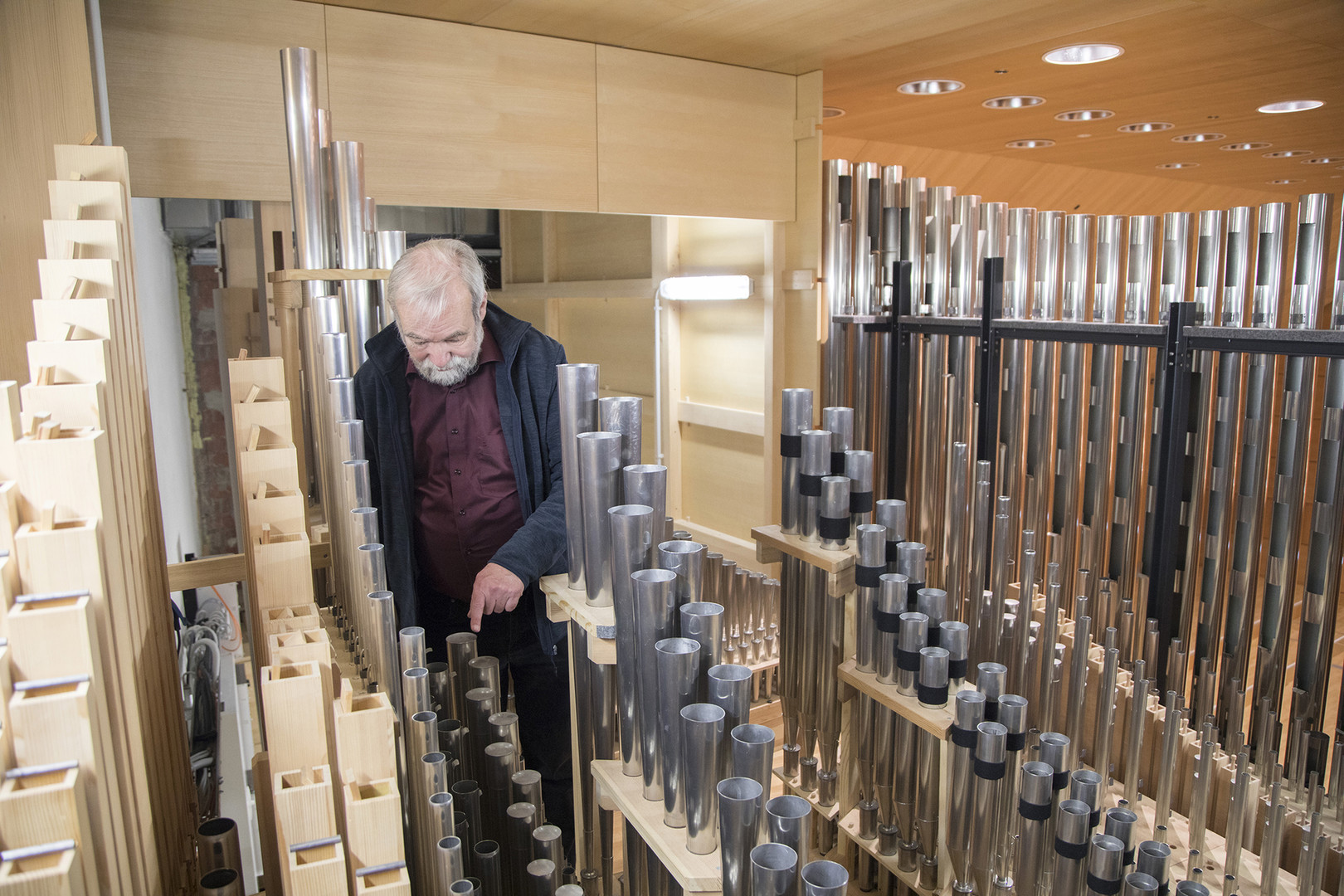 Herr Professor Christoph Bossert steht im Inneren der Orgel in der Würzburger Musikhochschule 