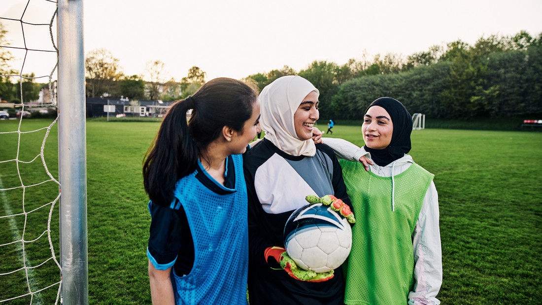 Mädchen mit und ohne Kopftuch freuen sich beim Fußball