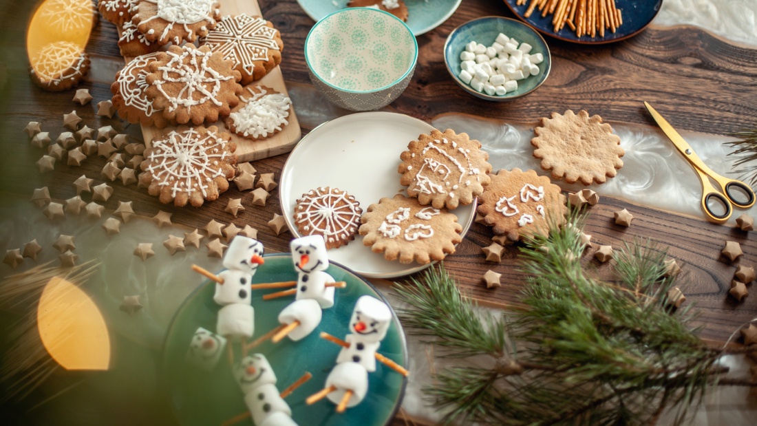 Tisch mit Weihnachsdekoration, Plätzchen und Marshmallow-Schneemännern