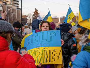 Demonstrantin in Kanada hält ein Schilde mit den Worten 'Help Ukraine' in den Händen