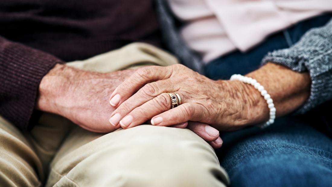 Senior Paar hält sich liebend die Hände