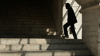 Eine Person läuft im Schatten eine Treppe hinauf.