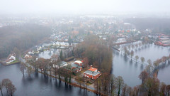 Luftbild mit Blick auf überschwemmte Felder und Grundstücke.