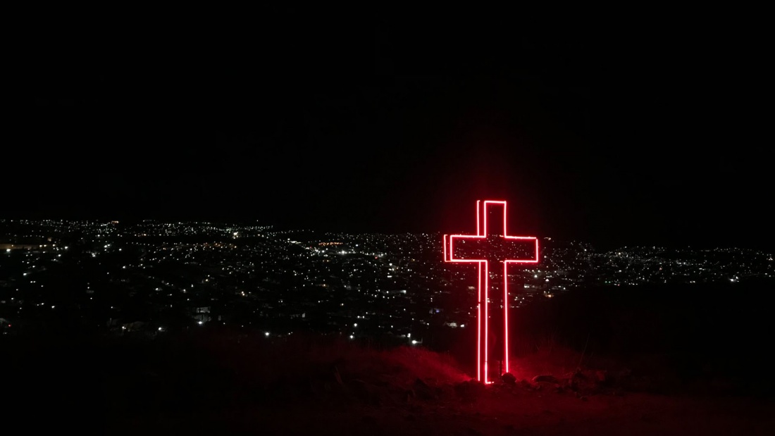 Leuchtendes Kreuz auf Berg
