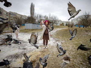 Eine Frau füttert Tauben im Stadtteil Saltiwka/Charkiw