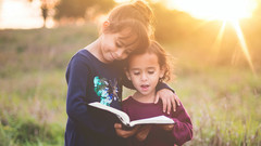 Zwei Mädchen lesen in einem Buch.