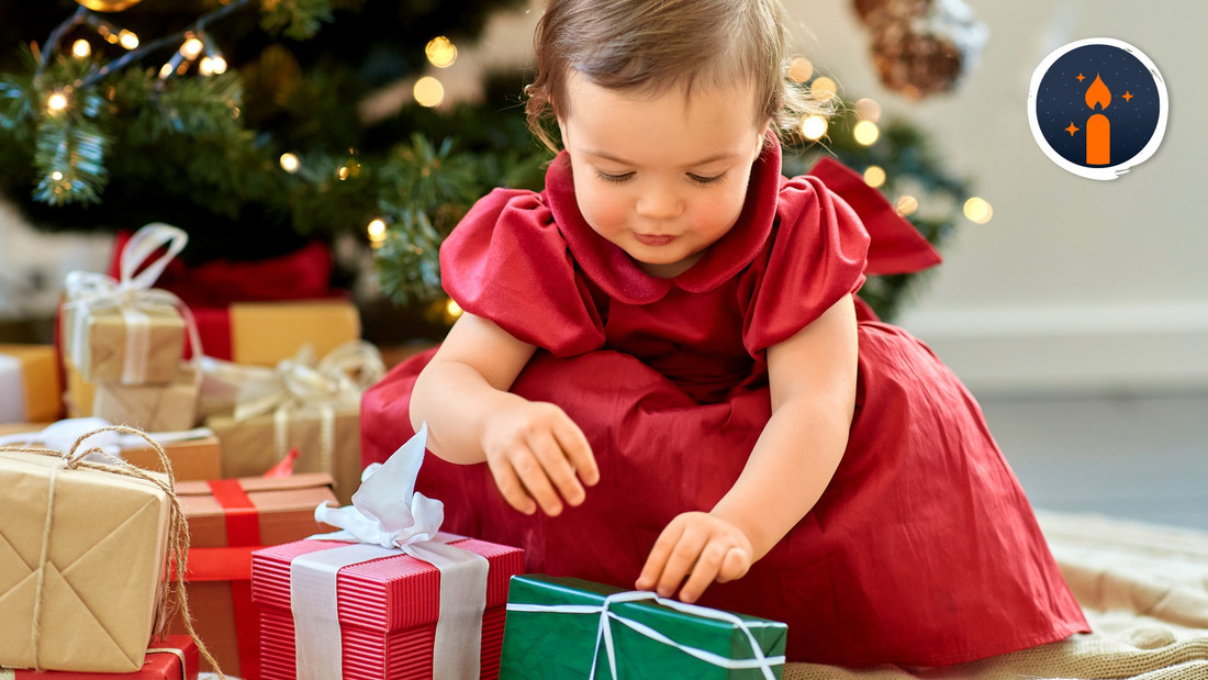 Baby mit Geschenken unterm Weihnachtsbaum