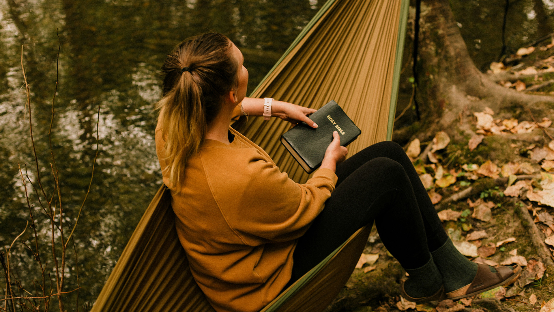 Frau mit Bibel in Hängematte