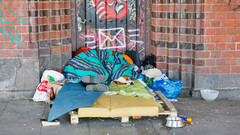 Obdachlose Person schläft auf einer Matratze auf der Straße