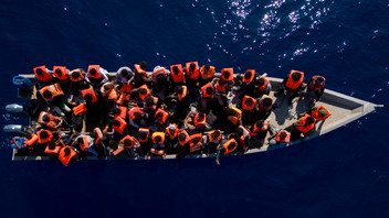 Migranten aus Eritrea, Libyen und dem Sudan sitzen in einem Holzboot