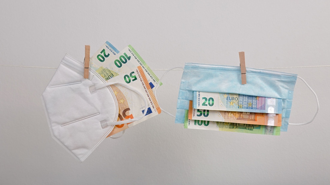 Corona Mundschutze mit Geld darin hängen auf der Wäscheleine