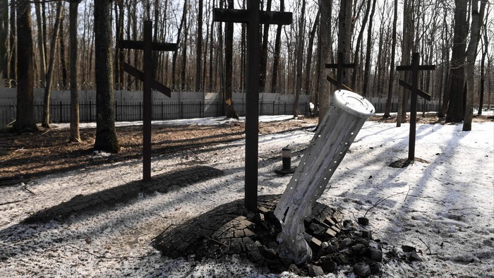 Kreuze auf dem Kriegsfriedhof in Charkiw, Ukraine. Direkt neben einem Kreuz ist eine mutmaßlich russische Streubombe eingeschlagen.