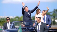 Brasiliens Präsident Jair Bolsonaro winkt, während er mit seiner Ehefrau Michelle in einem offenen Rolls Royce durch die Hauptstadt Brasilia fährt.