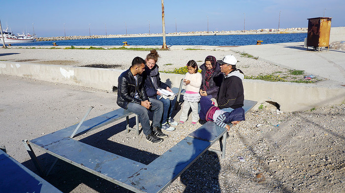 An der EU-Außengrenze: Donata Hasselmann berät Flüchtlinge auf eine Bank am Hafen in Chios
