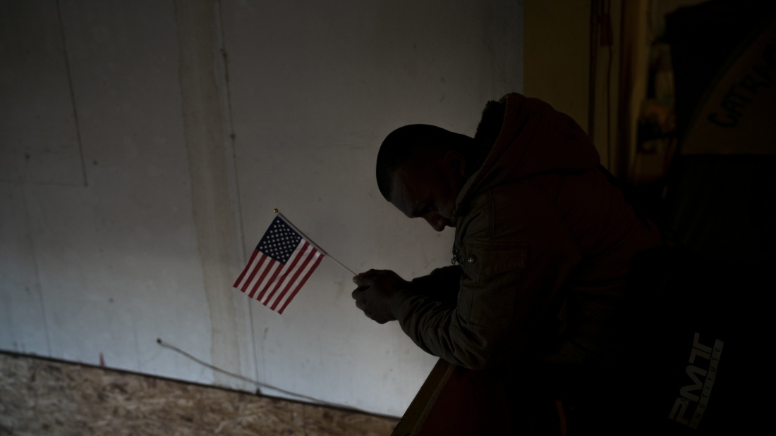Ein Migrant aus Honduras hält eine US-Flagge in einem leeren Lagerhaus, das als Unterkunft für Migranten dient. Migrationsexperten befürchten eine humanitäre Krise an der Grenze, sollten die Vereinigten Staaten vermehrt mittelamerikanische Migranten in mex