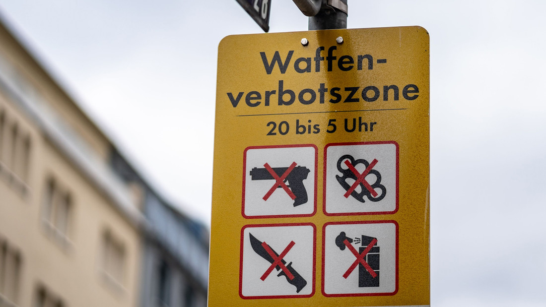 Straßenschild weist auf Waffenverbote mit Piktogrammen hin