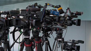 Fernsehkameras auf Stativen bei einer Pressekonferenz.