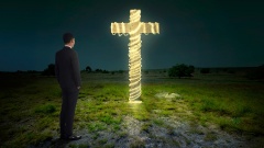 Mann steht vor erleuchtetem Kreuz