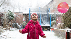 Mädchen freut sich über Schneeflocken