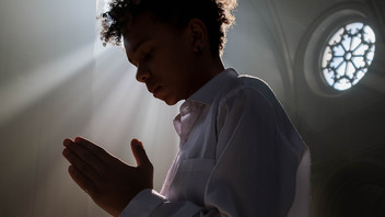 Junge betet in Kirche