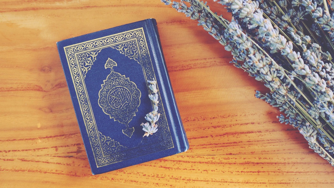 Kleiner Koran neben Blumen