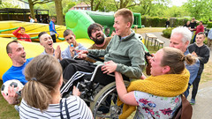 Ukrainische Kinder und Jugendliche mit  Behinderung lassen ein Geburtstagskind mit Rollstuhl hochleben.