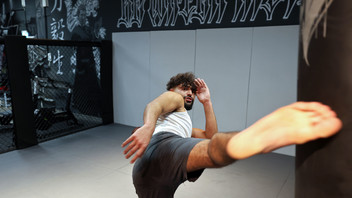 Mann trainiert Kickboxen in einer Halle.