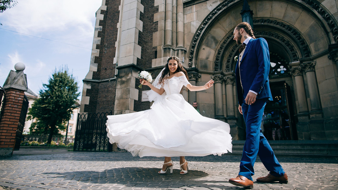 Brautpaar tanzt vor der Kirche 
