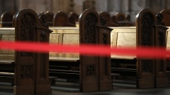 Ein Teil der Kirchenbänke im Kölner Dom ist wegen der Corona-Krise abgesperrt.