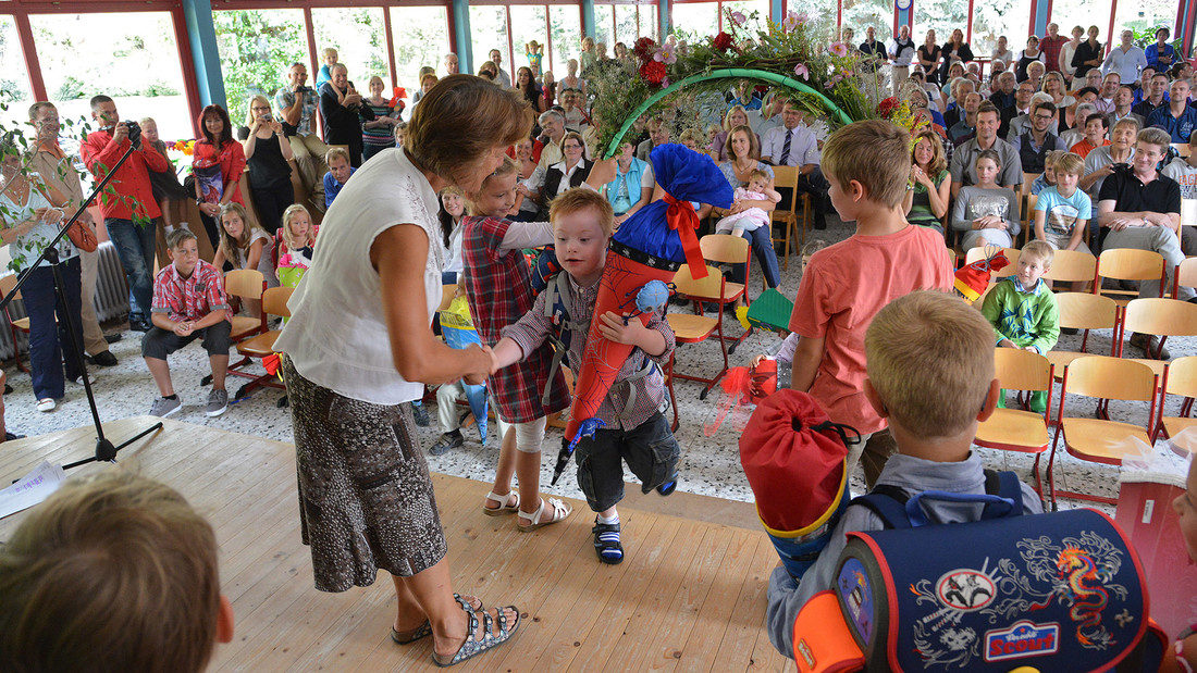 Schulanfänger mit Schultüten bei der Einschulungsfeier in einer Aula