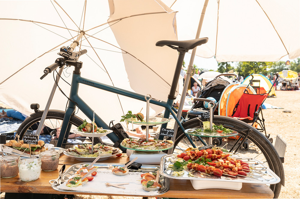 Ein Tauffest wie ein großes Picknick. Unter den schützenden Sonnenschirmen finden sich auch ein paar Snacks, um den Nachmittag zu überstehen