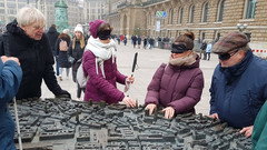 Am Hamburger Rathausmarkt ertasten die Teilnehmenden einer Begleiterschulung ein Modell der Stadt.