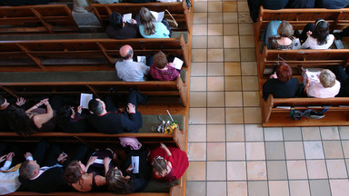 Kirchenbänke mit sitzenden Menschen