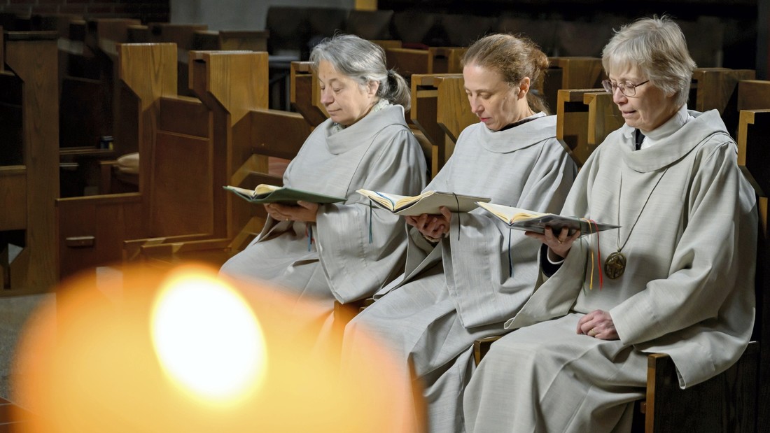 Drei Nonnen sitzen in der Kirche