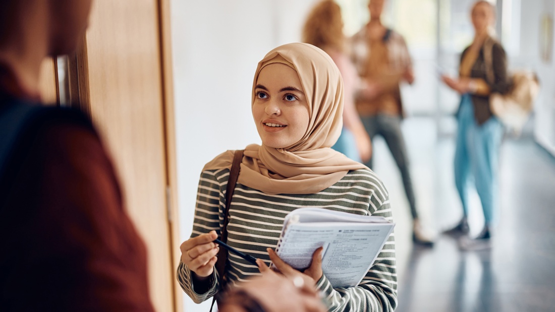 eine Muslima im Gespräch in einer Uni oder Schule