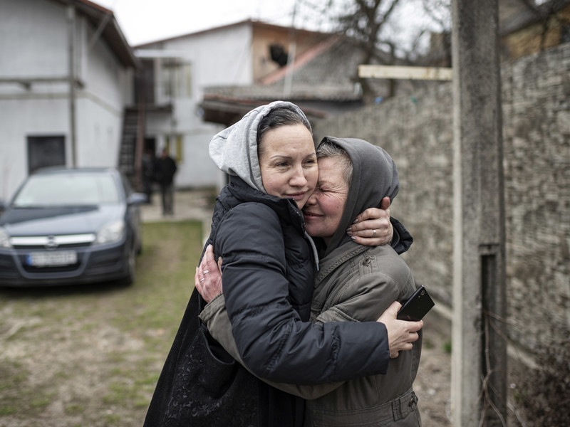 Olia (rechts) umarmt ihre Nachbarin, die nach Butscha (Ukraine) zurückkehrt