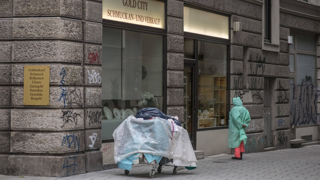 Armut in der Stadt: Eine obdachlose Frau schaut sich das Schaufenster von Gold City an