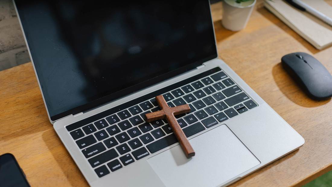 Stillleben mit Laptop und Holzkreuz