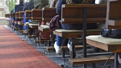 Betende Menschen auf Kirchenbänken in Winterkleidung