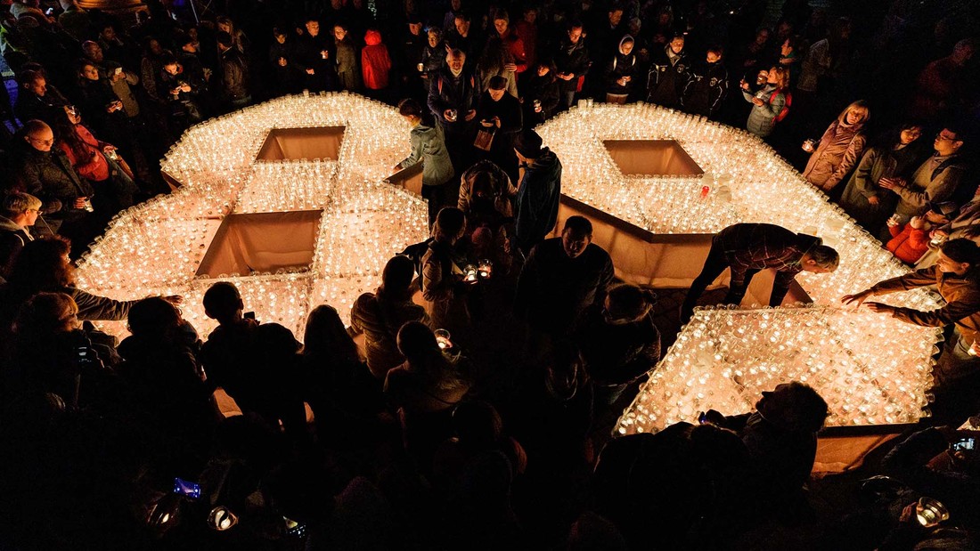 Das Lichtfest in Leipzig im Jahr 2022: Menschen stellen mit Kerzen die Ziffer 89 während des Lichtfests vor der Leipziger Nikolaikirche