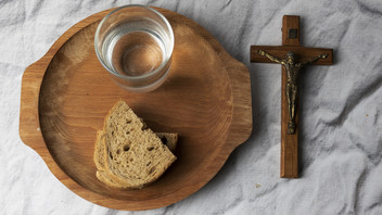 Wasser, Brot und Kreuz auf einem Tisch