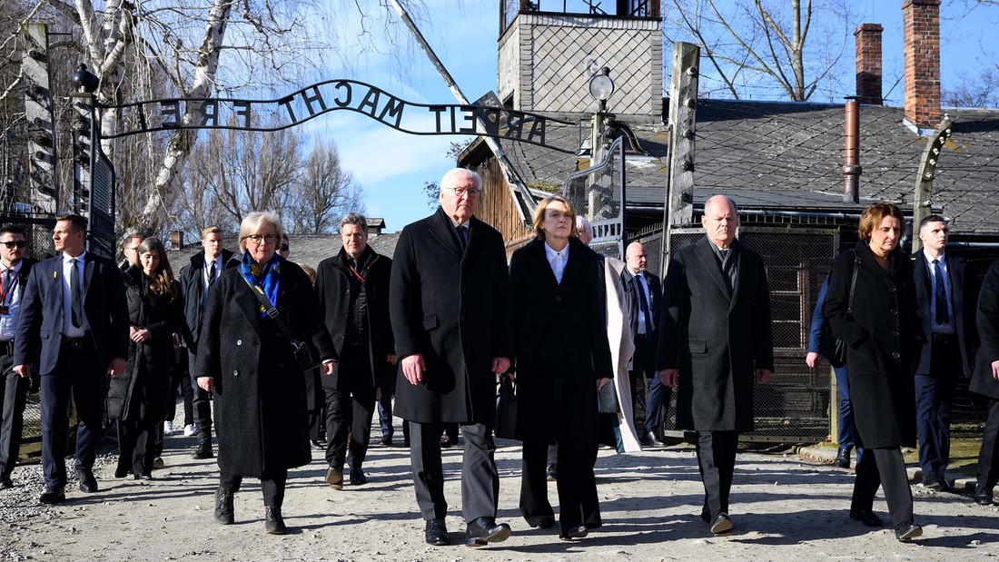 Bundespräsident Frank-Walter Steinmeier und seine Frau Elke Büdenbender gehen zusammen mit Bundeskanzler Olaf Scholz (SPD) und seiner Frau Britta Ernst durch das Tor des ehemaligen deutschen Konzentrations- und Vernichtungslager Auschwitz-Birkenau