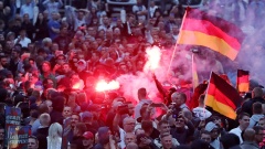 Demonstranten der rechten Szene zünden Pyrotechnik und schwenken Deutschlandfahnen bei den Ausschreitungen in Chemnitz.