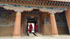 Zwei junge Mönche gehen durch den Ausgang des Gangtey-Klosters