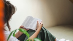 Frau liest nachdenklich in Bibel