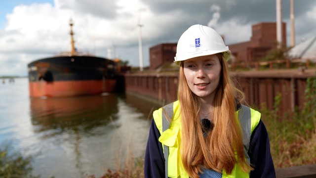 Eine Frau mit Baustellenhelm.