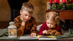 Kinder beim Lesen in weihnachtlichem Umfeld